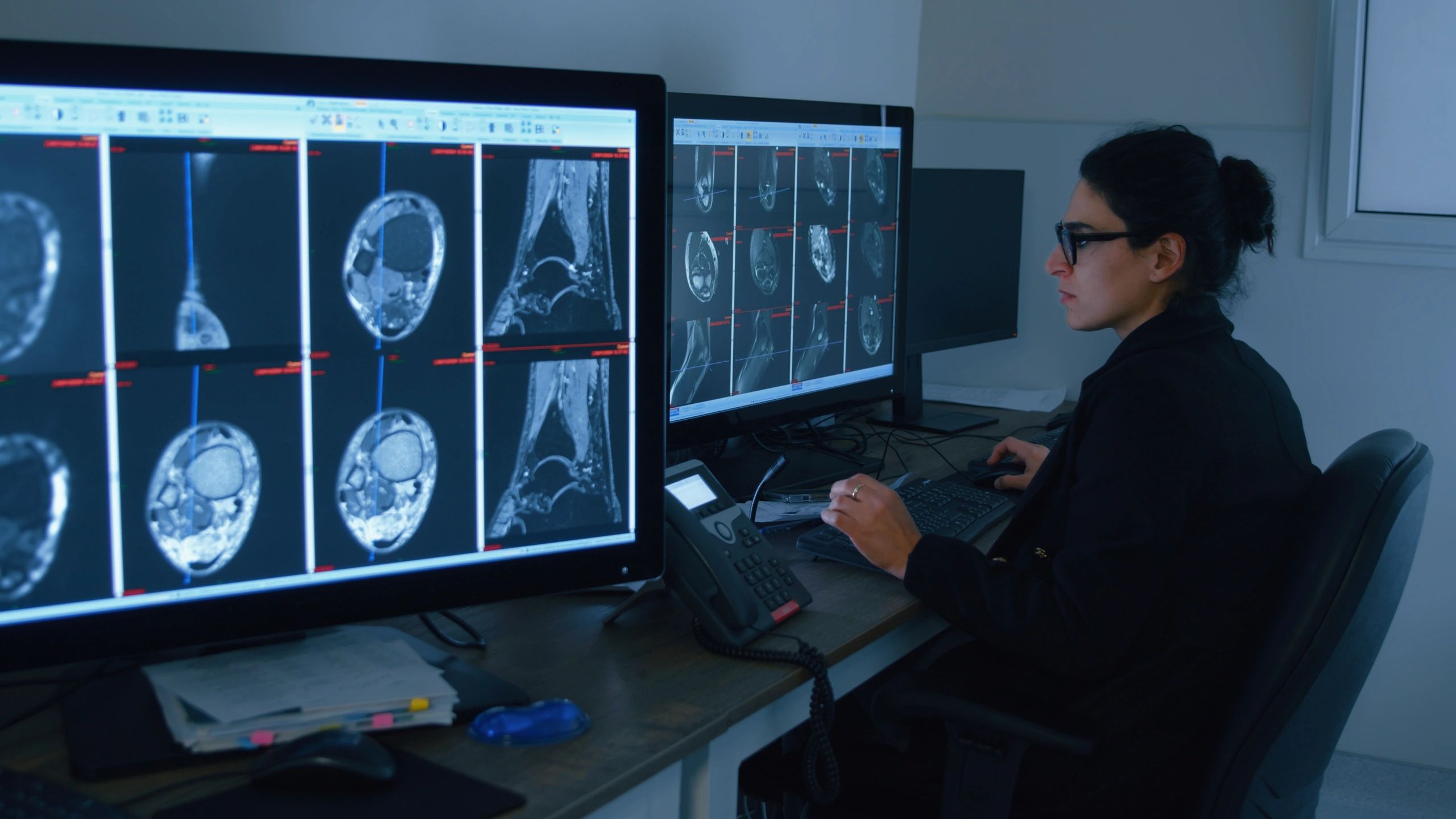 Analyst working across multiple computer monitors
